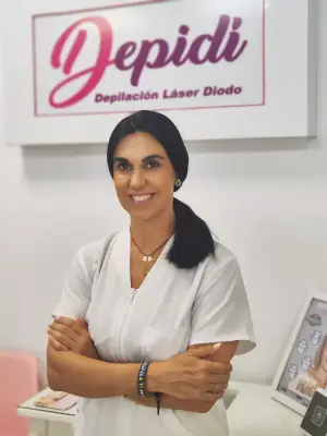 Profesional de estética posando en el centro Depidi junto al logotipo de la clínica.